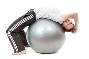 Mujer realizando ejercicio en una pelota de yoga