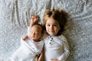 niña acostada junto a su hermano pequeño