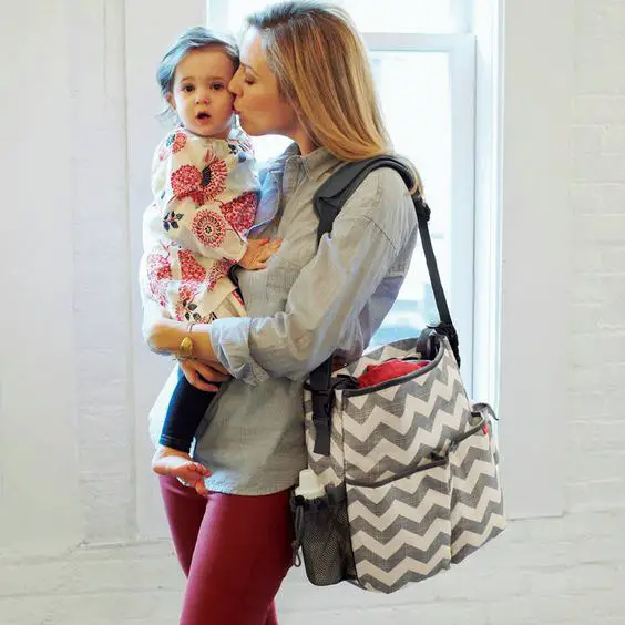 Mamá con bebé en brazos y bolso maternal Mamá con bebé en brazos y bolso maternal