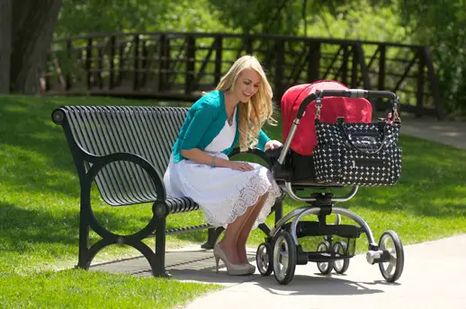 Mujer en el parque con el coche de su bebé Mujer en el parque con el coche de su bebé