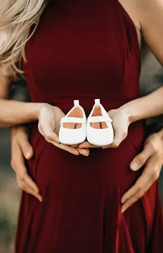 Embarazada con zapatos de bebé
