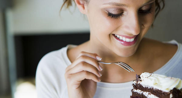 Mujer feliz comiendo torta de chocolate