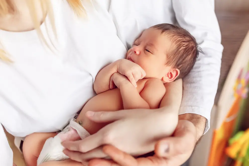 bebé de 1 mes en brazos de sus padres