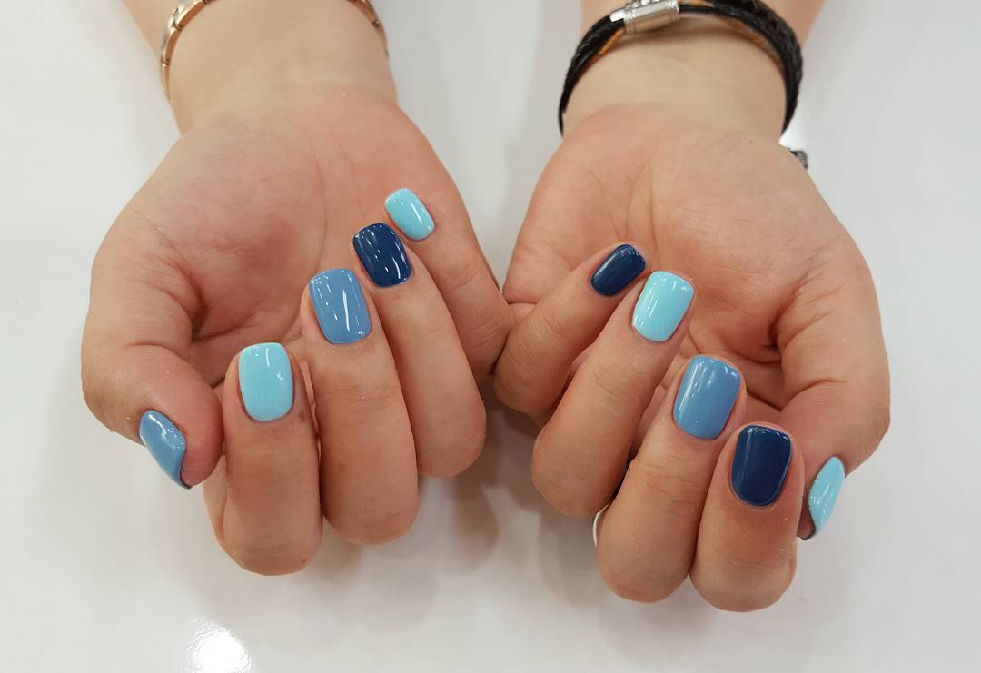 Uñas largas ovaladas de moda con diferentes tonos de esmalte de uñas desde  azul claro hasta turquesa  Foto Premium